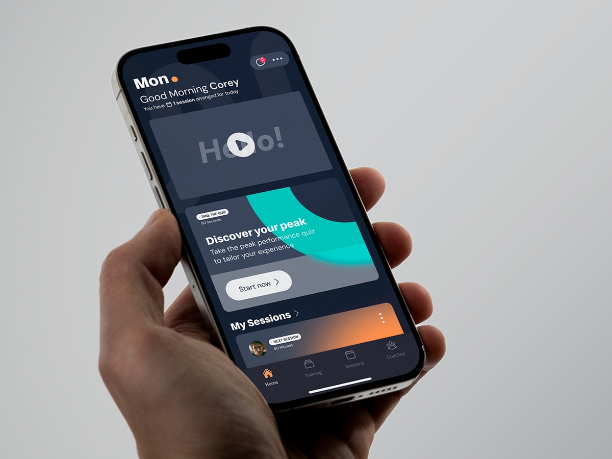 A hand holding an iphone towards them with the MindReady App dashboard displayed on it's screen in dark mode.